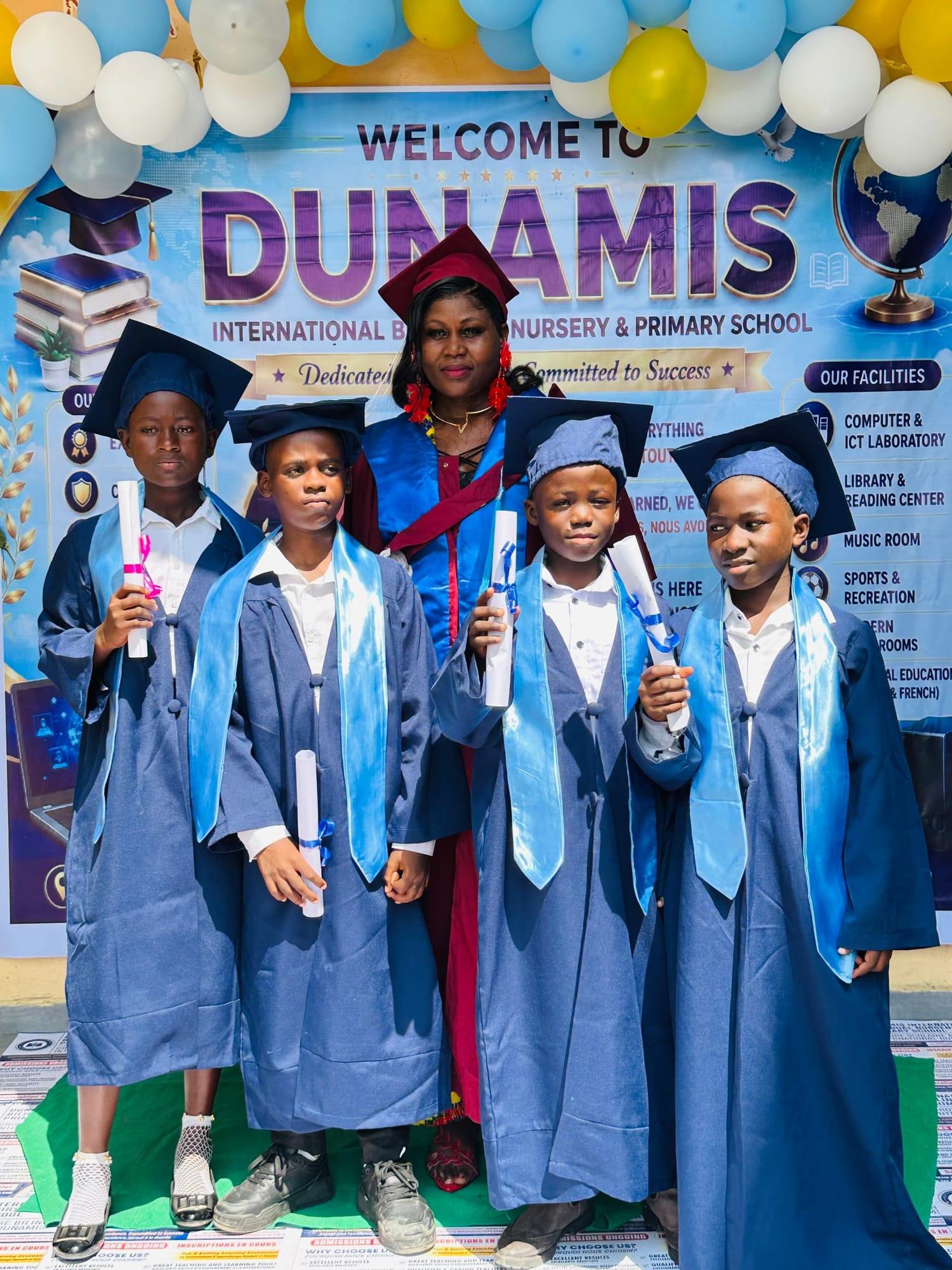Des élèves diplômés avec un membre du personnel en tenue académique brandissant leur diplôme