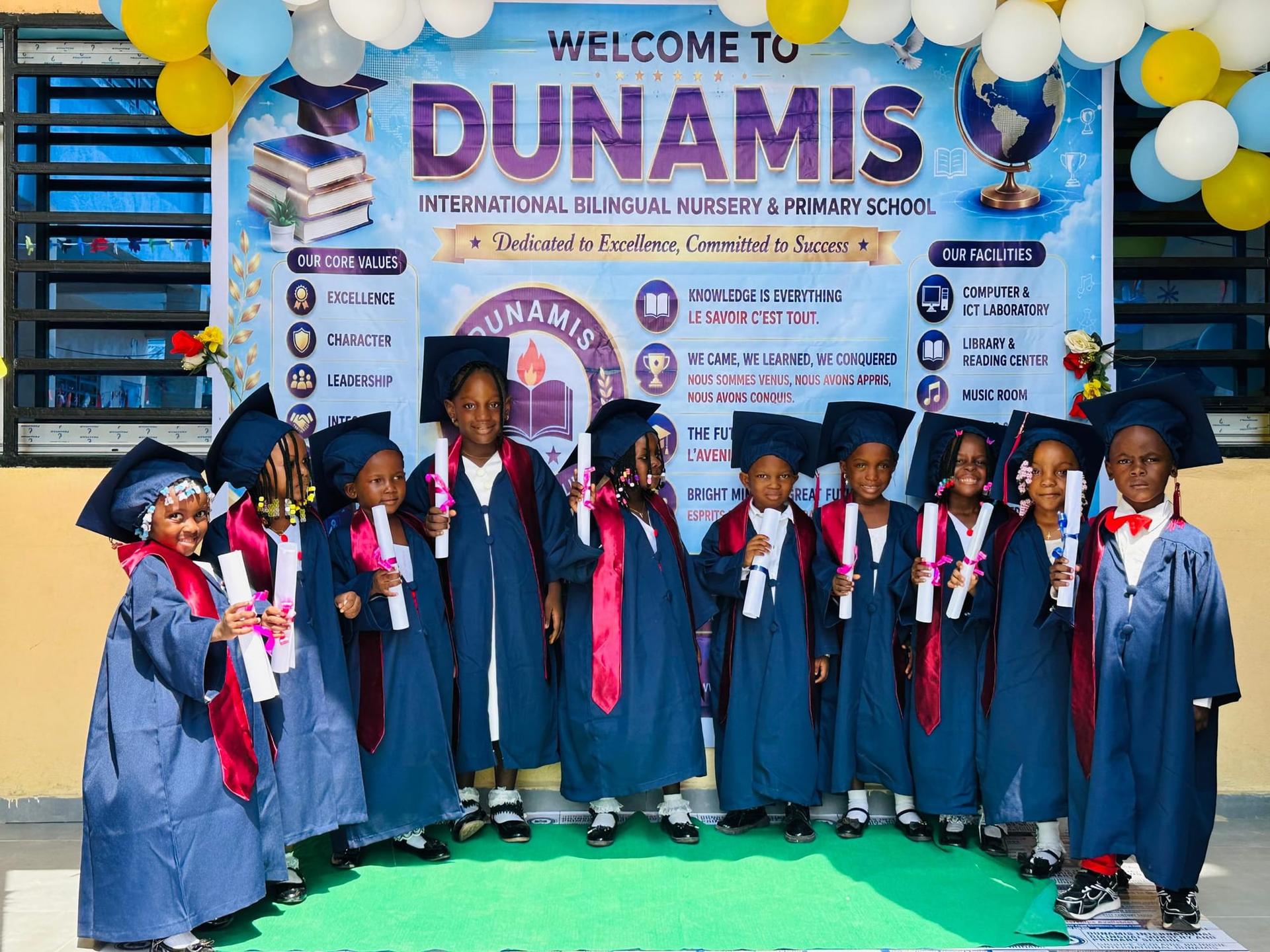 Des élèves diplômés alignés en toge et toque pour une photo de groupe lors de la cérémonie