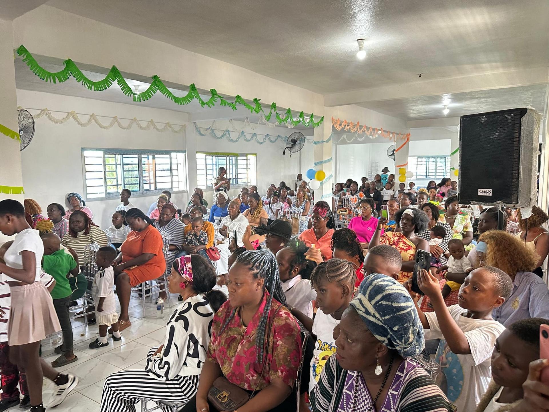 Parents et familles réunis dans une salle décorée pour la cérémonie de remise des diplômes
